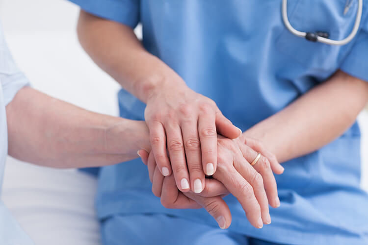 Nurse holding a patient's hand